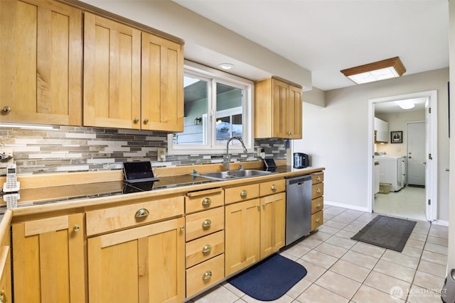kitchen featuring stainless steel dishwasher, a sink, separate washer and dryer, light brown cabinetry, and tasteful backsplash