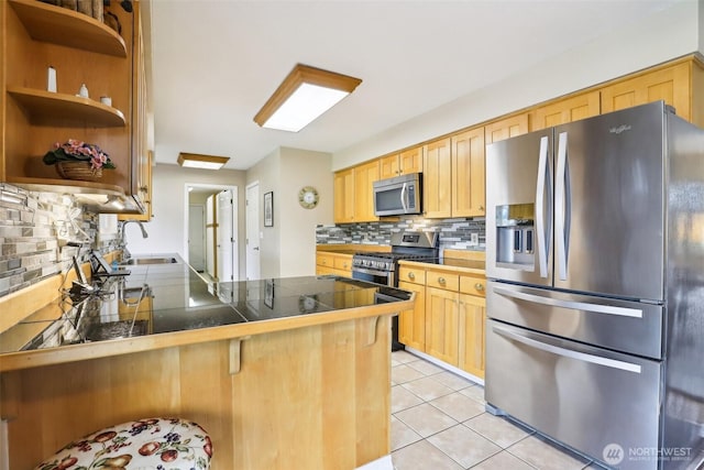 kitchen with stainless steel appliances, tasteful backsplash, a peninsula, a kitchen breakfast bar, and light tile patterned floors