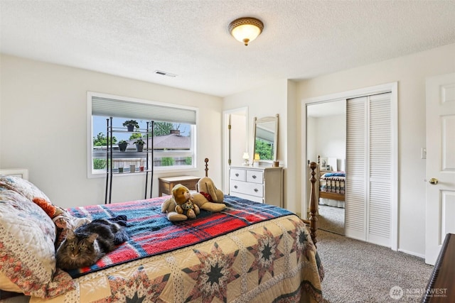 carpeted bedroom with a closet and a textured ceiling