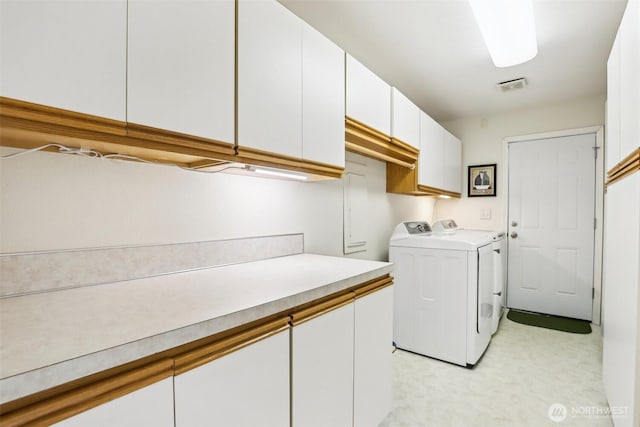 washroom featuring independent washer and dryer and cabinet space