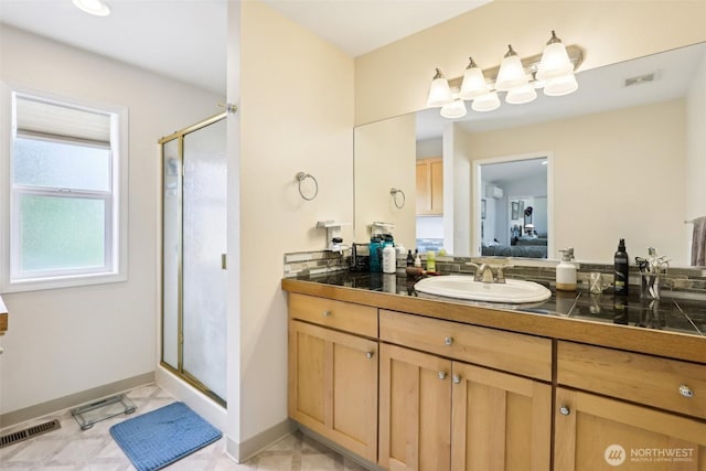 bathroom with a shower stall, connected bathroom, vanity, and baseboards