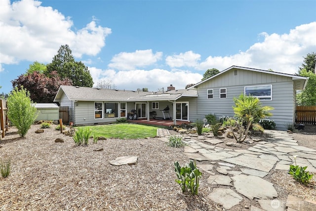 back of house featuring a fenced backyard, a patio, and a chimney