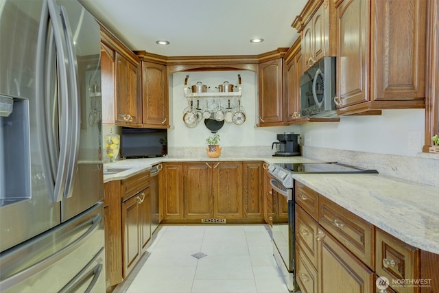 515 N Shelley Ave, Othello, WA 99344 - kitchen featuring stainless steel appliances, light tile patterned floors, light stone counters, brown cabinets, and recessed lighting