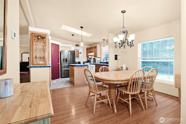 178 Bear View Dr, Chehalis, WA 98532 - dining room featuring a chandelier, light wood-style floors, vaulted ceiling, and a skylight