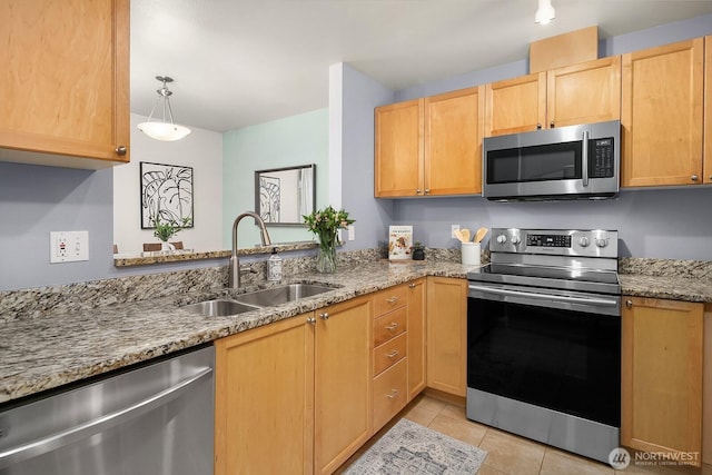 kitchen with stainless steel appliances, a sink, light tile patterned flooring, light stone countertops, and light brown cabinetry