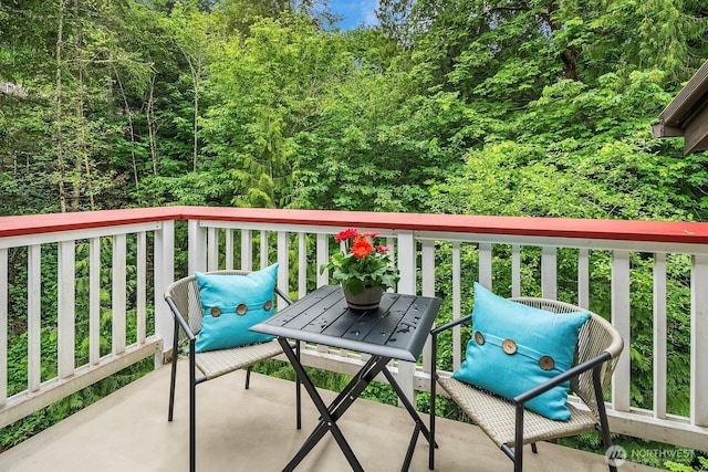 balcony featuring a wooded view
