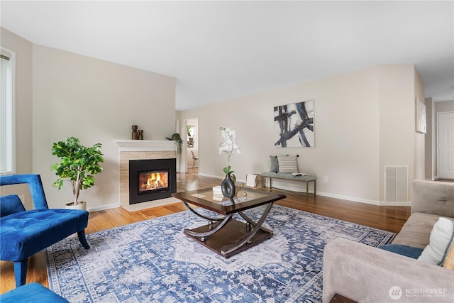 4037 220th Pl SE Unit 1105, Issaquah, WA 98029 - living area with wood finished floors, a tile fireplace, and baseboards
