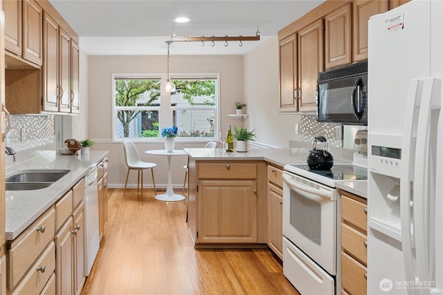 4037 220th Pl SE Unit 1105, Issaquah, WA 98029 - kitchen featuring white appliances, a peninsula, a sink, light wood-style floors, and tasteful backsplash
