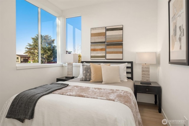 bedroom featuring wood finished floors and baseboards