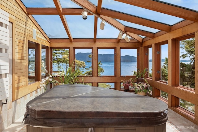 871 Deer Point Rd, Orcas Island, WA 98279 - sunroom featuring a hot tub, a water view, wooden walls, and a skylight