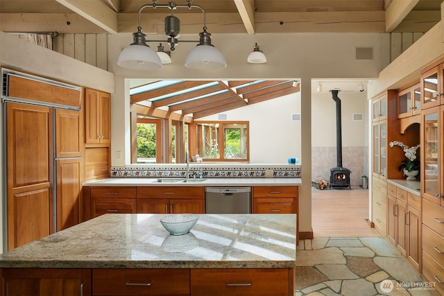 871 Deer Point Rd, Orcas Island, WA 98279 - kitchen with stainless steel dishwasher, a sink, a wood stove, and brown cabinets