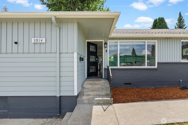 doorway to property featuring board and batten siding and crawl space
