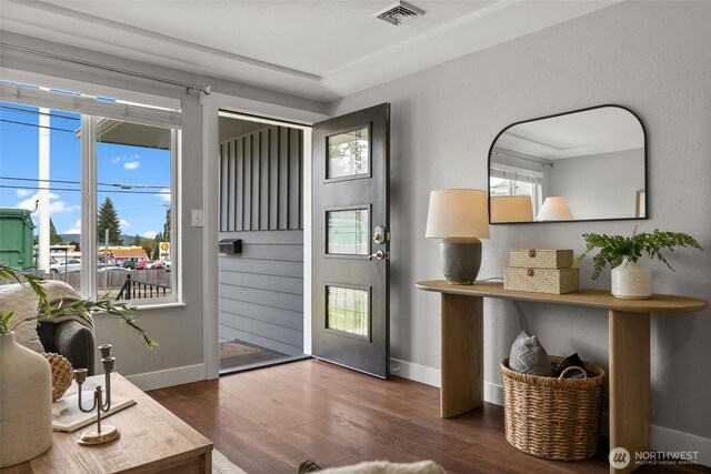 doorway with baseboards and wood finished floors