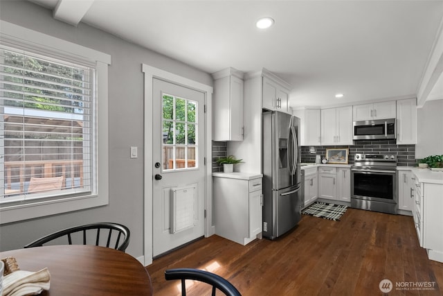kitchen featuring stainless steel appliances, light countertops, dark wood-style floors, decorative backsplash, and recessed lighting