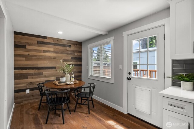 dining area with wooden walls, wood finished floors, baseboards, and recessed lighting