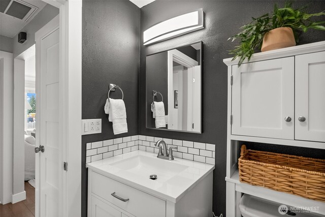 bathroom with vanity, wood finished floors, decorative backsplash, and toilet