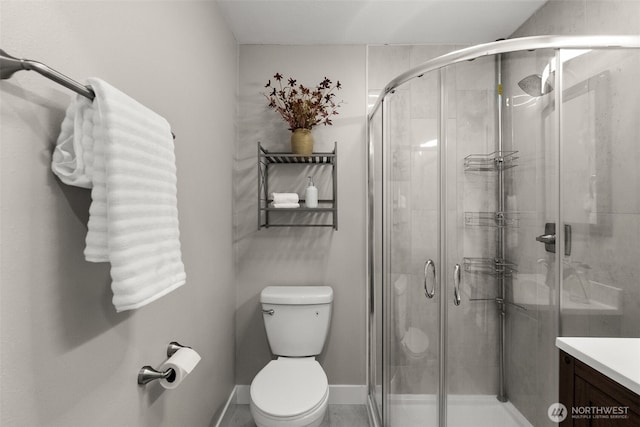 bathroom with toilet, vanity, and a shower stall