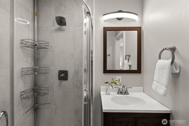 full bath with a stall shower and vanity