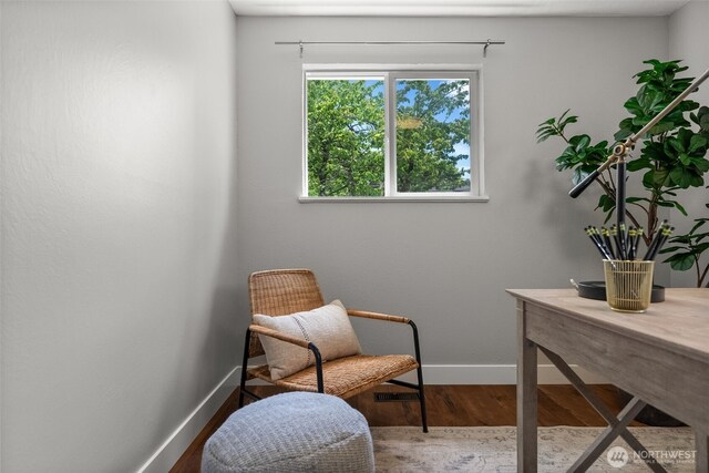 sitting room with baseboards and wood finished floors