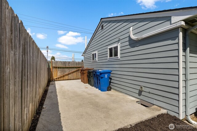 view of home's exterior with fence and a patio area