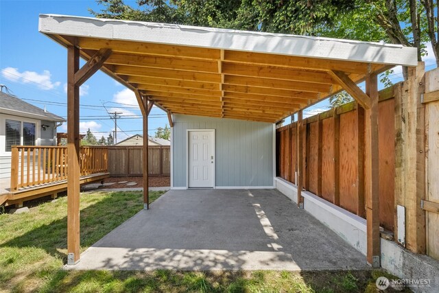 view of patio featuring a wooden deck and a carport