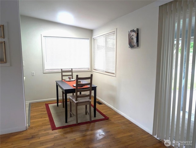 dining room featuring wood finished floors and baseboards