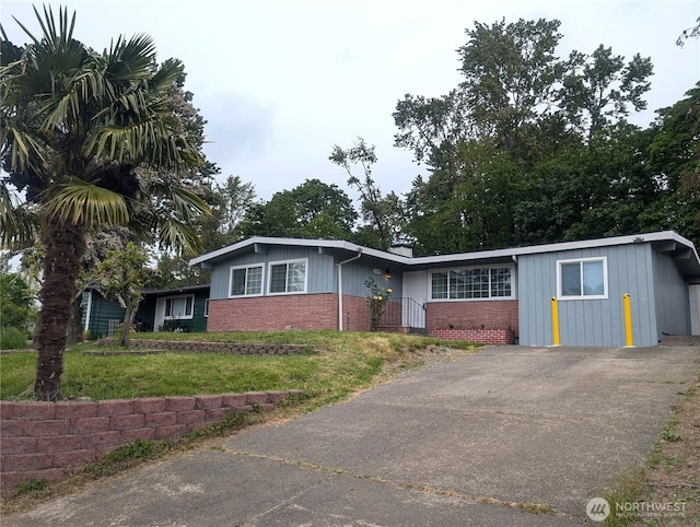 single story home with brick siding and a front lawn