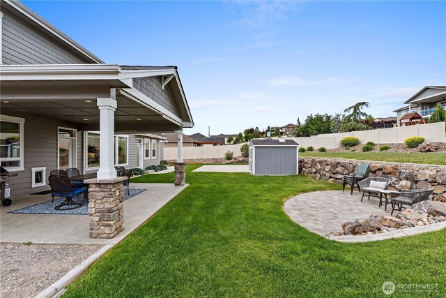 view of yard with a patio area, a storage shed, and an outbuilding