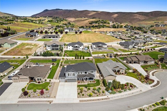 aerial view of property and surrounding area featuring nearby suburban area and mountains
