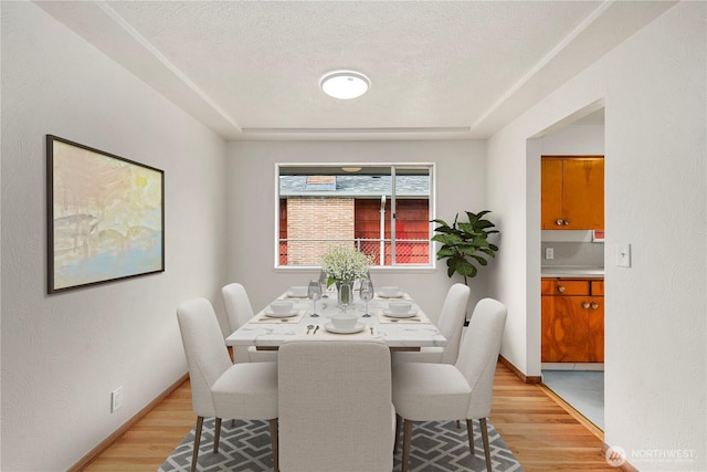 1113 S 72nd St, Tacoma, WA 98408 - dining space with light wood-type flooring, a textured ceiling, and baseboards