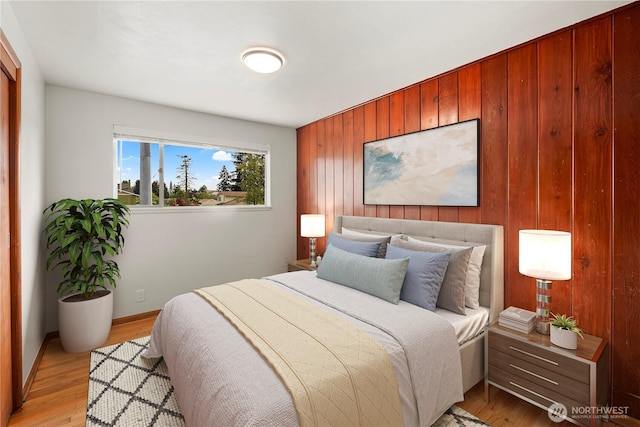 1113 S 72nd St, Tacoma, WA 98408 - bedroom featuring wooden walls, light wood-style floors, an accent wall, and baseboards