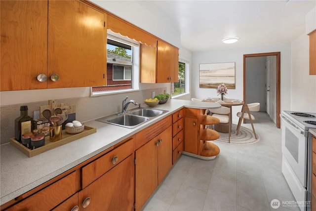 1113 S 72nd St, Tacoma, WA 98408 - kitchen with electric range, a sink, light countertops, and brown cabinetry