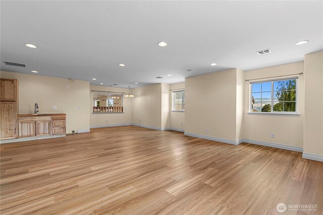 2060 5th St, Wenatchee, WA 98801 - unfurnished living room with healthy amount of natural light, light wood-style flooring, baseboards, recessed lighting, and a sink