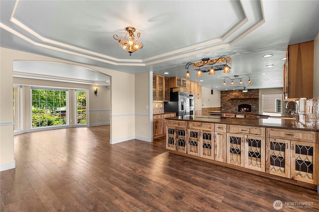 2060 5th St, Wenatchee, WA 98801 - kitchen with a tray ceiling, fridge with ice dispenser, a chandelier, glass insert cabinets, and baseboards