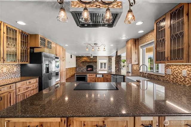 2060 5th St, Wenatchee, WA 98801 - kitchen with appliances with stainless steel finishes, a sink, a stone fireplace, backsplash, and dark stone countertops