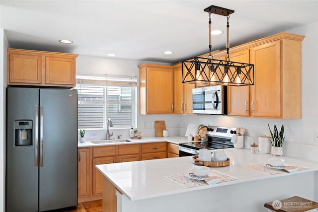 1123 N 94th St Unit A, Seattle, WA 98103 - kitchen with stainless steel appliances, a sink, a peninsula, light countertops, and hanging light fixtures