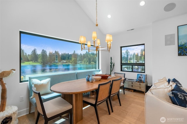 dining space with light wood-type flooring, a chandelier, recessed lighting, and vaulted ceiling
