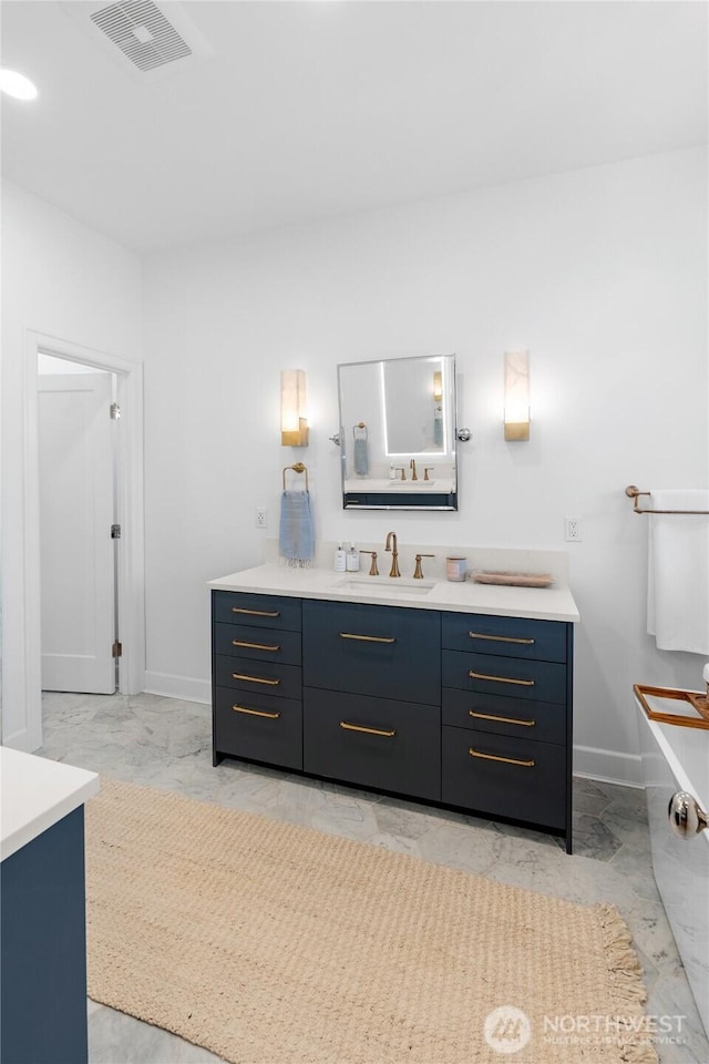 bathroom featuring baseboards, vanity, and marble finish flooring