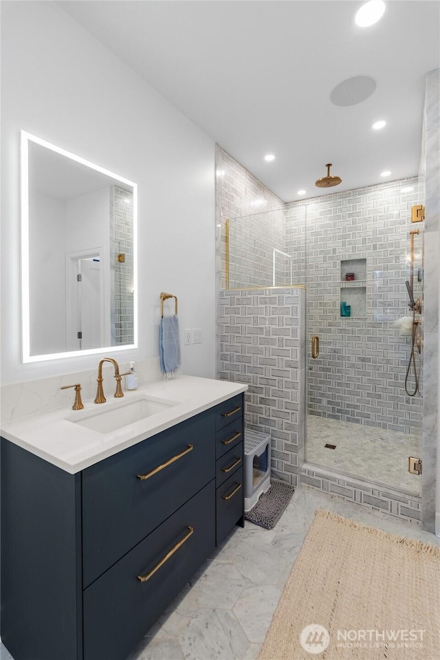 bathroom featuring a stall shower, marble finish floors, recessed lighting, and vanity
