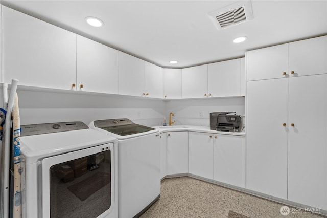 laundry room featuring washing machine and dryer, recessed lighting, and cabinet space