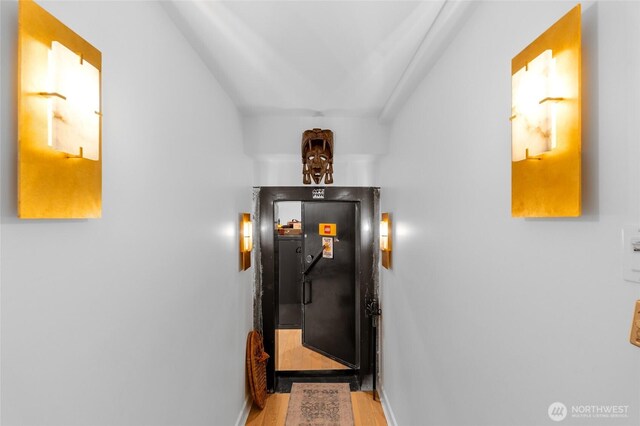 hall with wood finished floors and baseboards