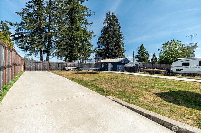 view of yard featuring a trampoline and a patio area