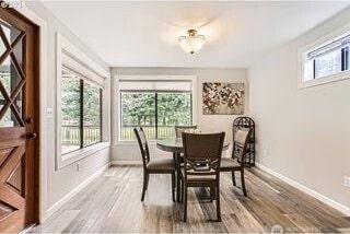 dining area featuring baseboards and light wood-style flooring