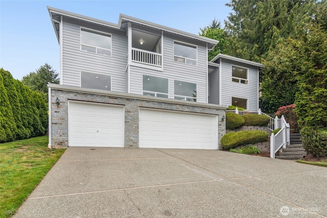 15428 SE 67th Pl, Bellevue, WA 98006 - view of front of home with a garage, concrete driveway, a balcony, and stone siding