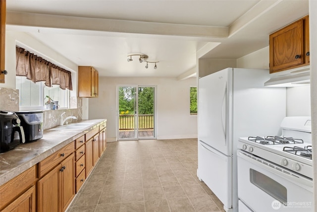 1025 NW Prindle St, Chehalis, WA 98532 - kitchen with white range with gas stovetop, under cabinet range hood, a sink, and brown cabinetry