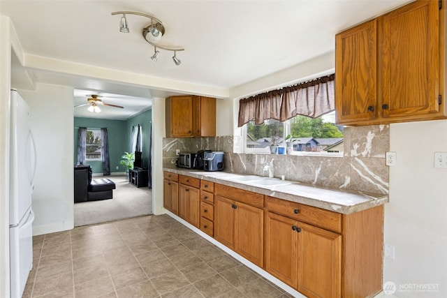 1025 NW Prindle St, Chehalis, WA 98532 - kitchen with freestanding refrigerator, light countertops, a sink, brown cabinetry, and a ceiling fan