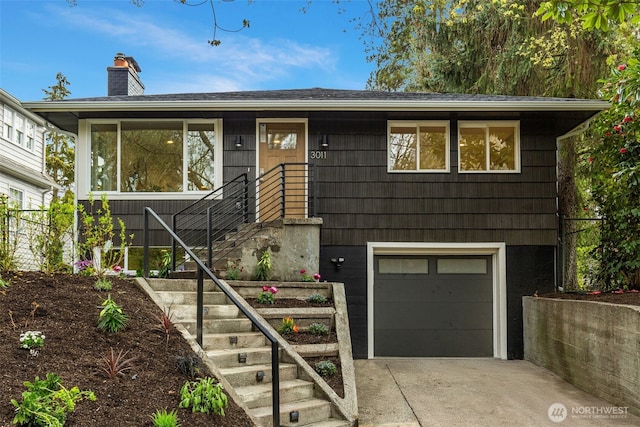 view of front facade featuring an attached garage, driveway, and a chimney