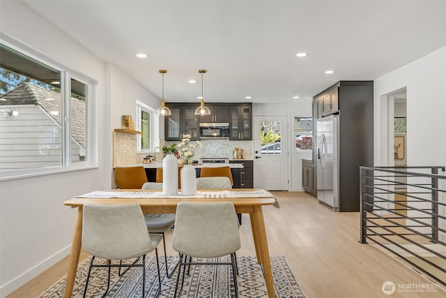 dining room with light wood-type flooring, recessed lighting, and baseboards