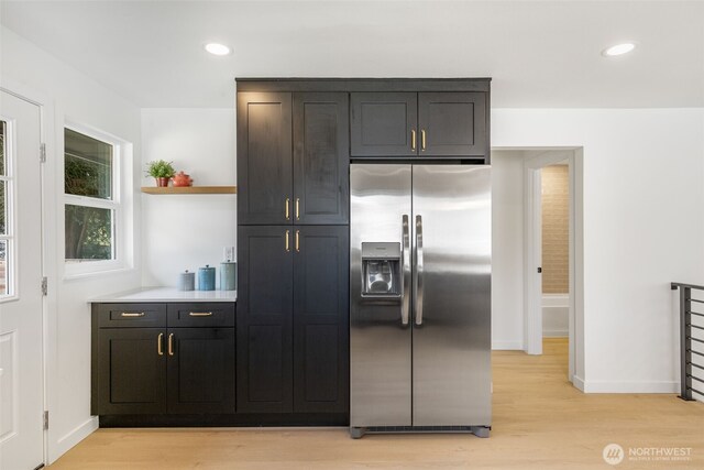 kitchen featuring stainless steel fridge with ice dispenser, open shelves, light wood-type flooring, baseboards, and recessed lighting
