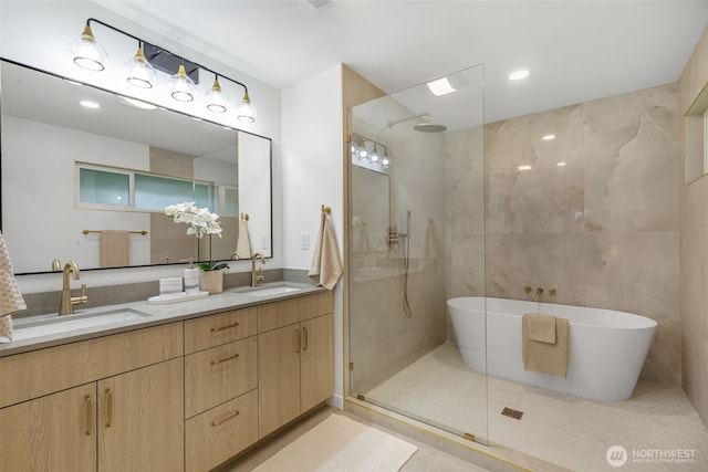 bathroom featuring walk in shower, double vanity, a soaking tub, recessed lighting, and tile patterned flooring